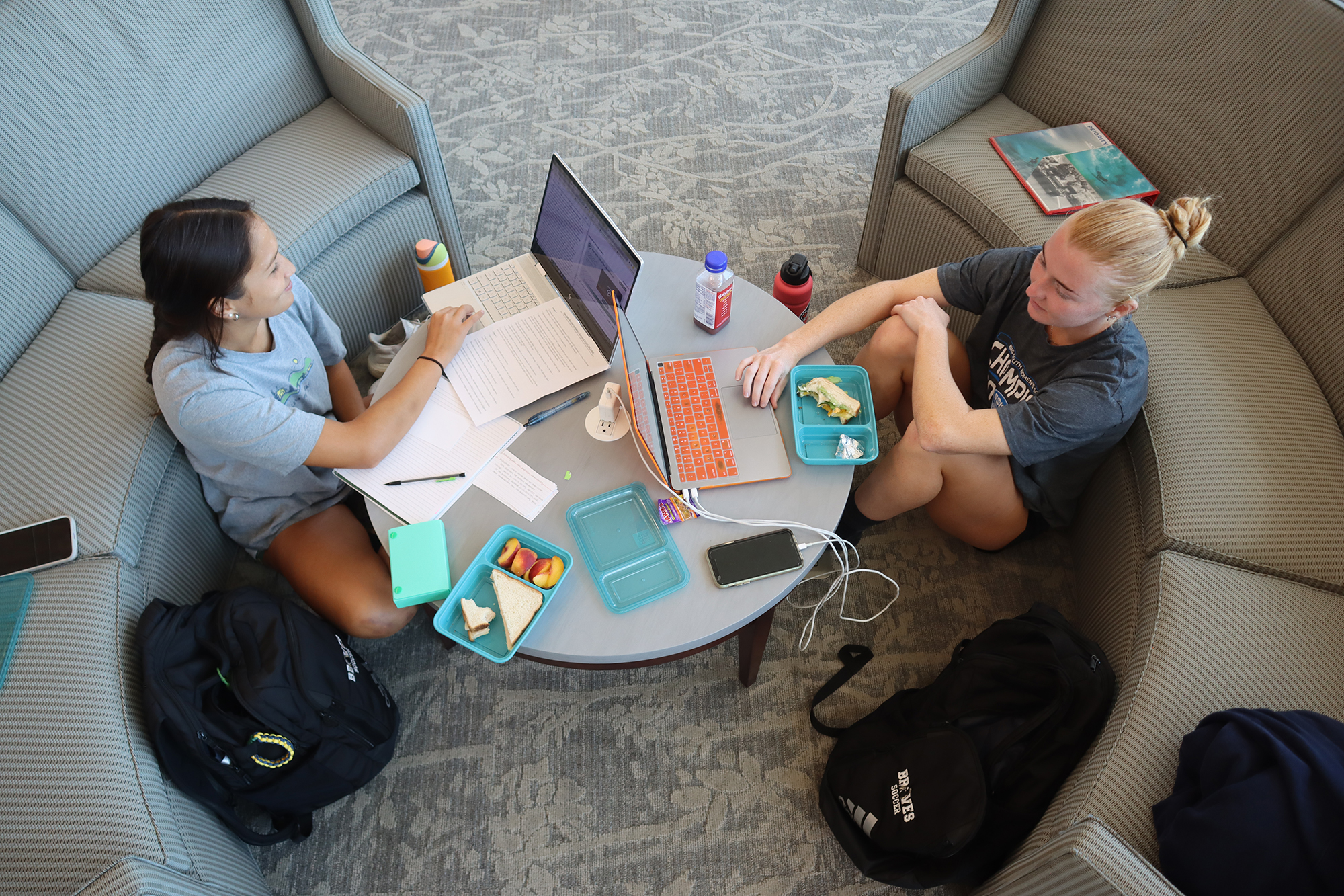 two female students sitting at a round table studying together