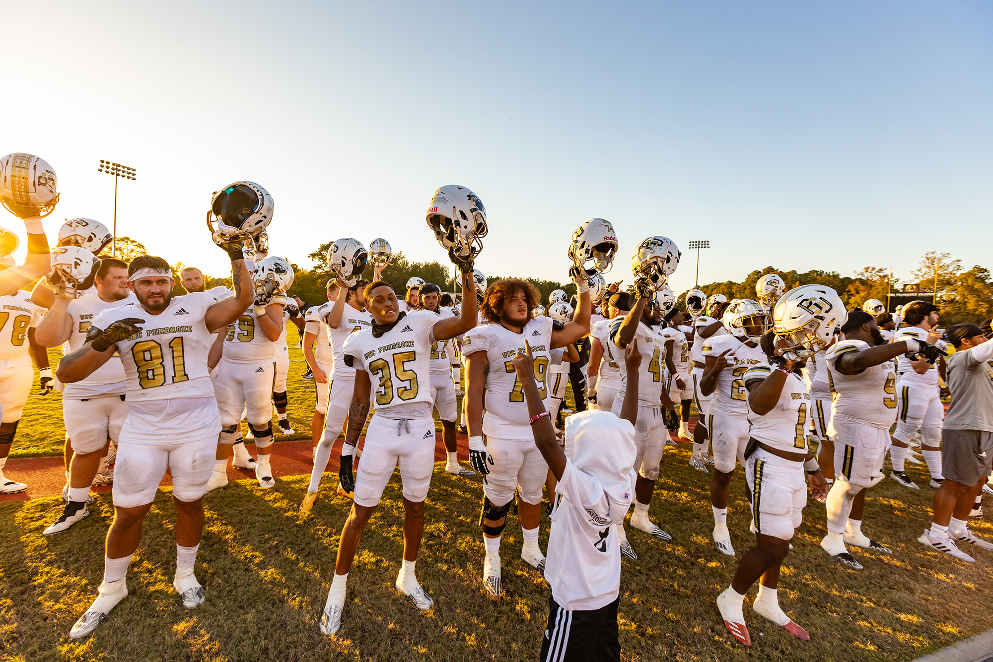 UNC Pembroke football team raises helmets in the air