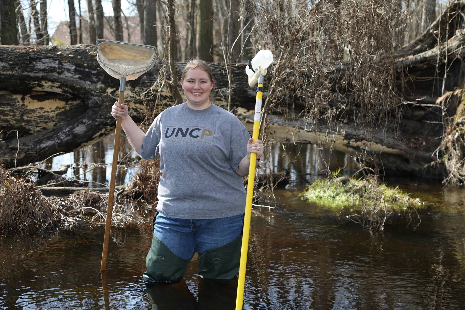 Dr. Amber Rock holding aquatics sampling gear