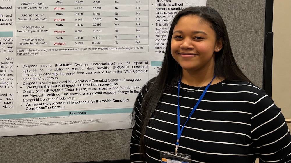 UNCP student Shelley Chavis stands in front of her poster.