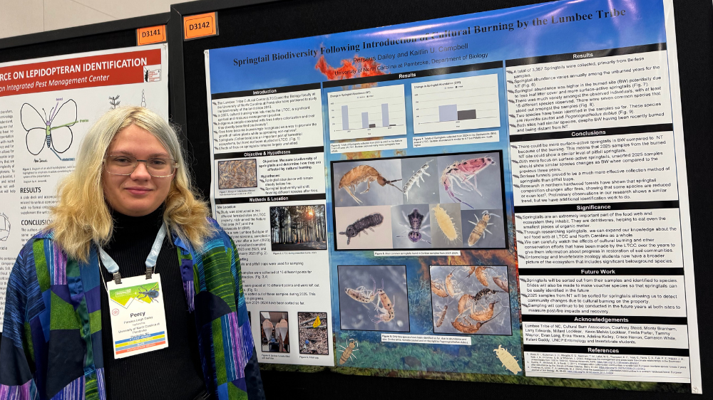 Perseus Daily stands next to his research poster