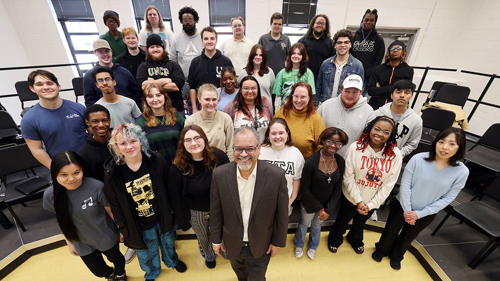Dr. Rivera standing in surrounded by his choir class in the background