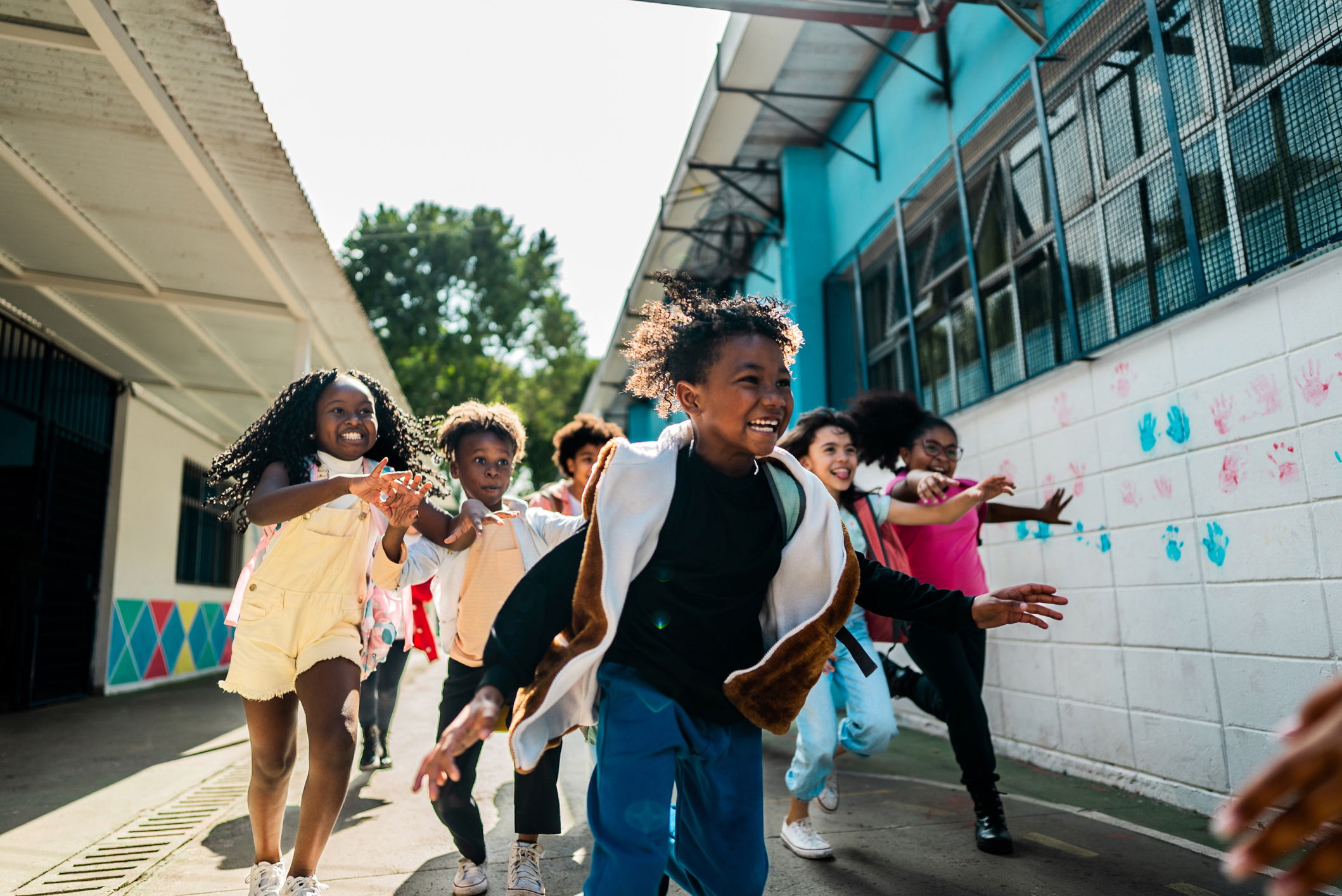 Children running outside near a school