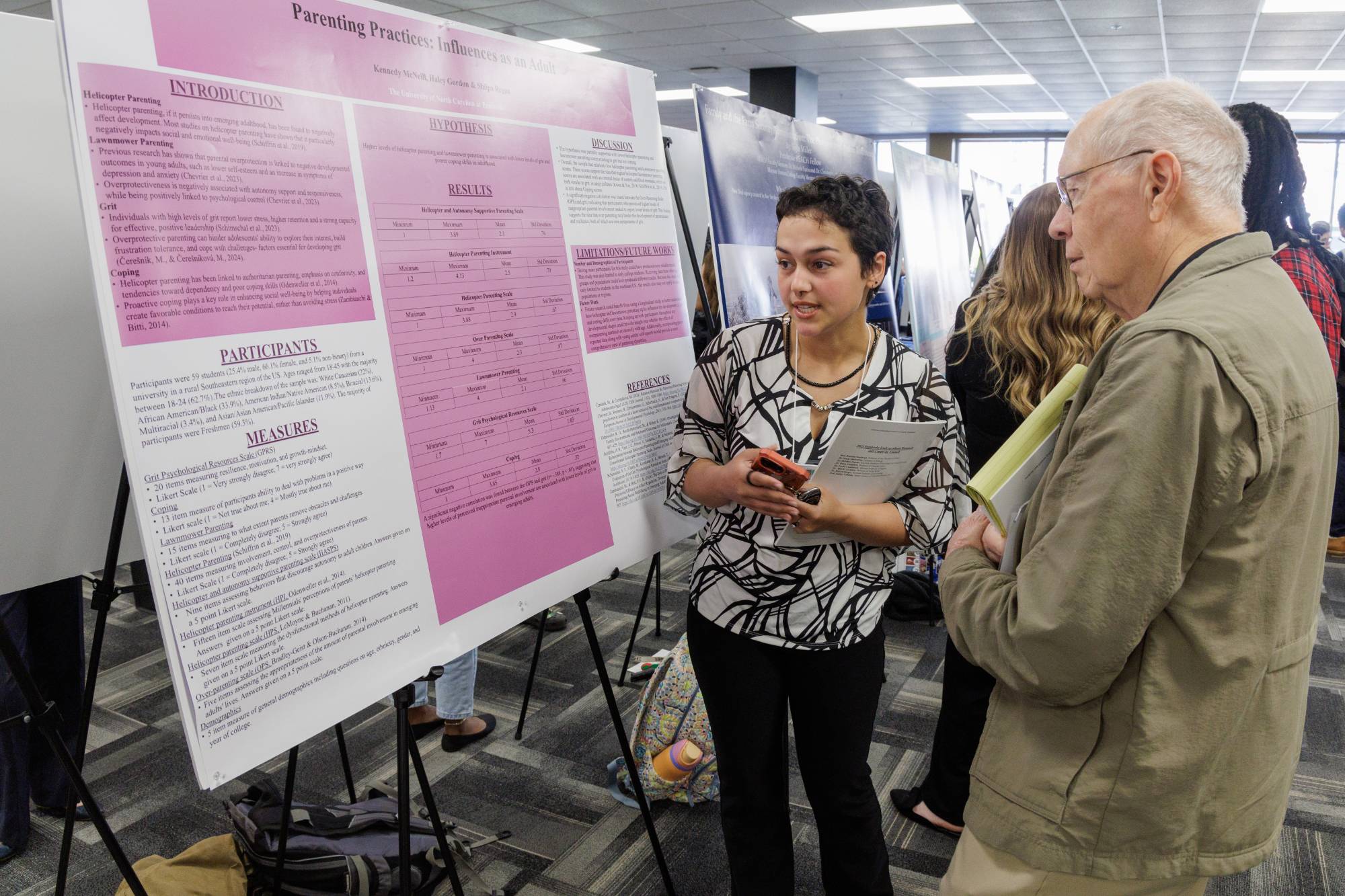 UNC Pembroke student presenting her research to a faculty member at a symposium poster session.