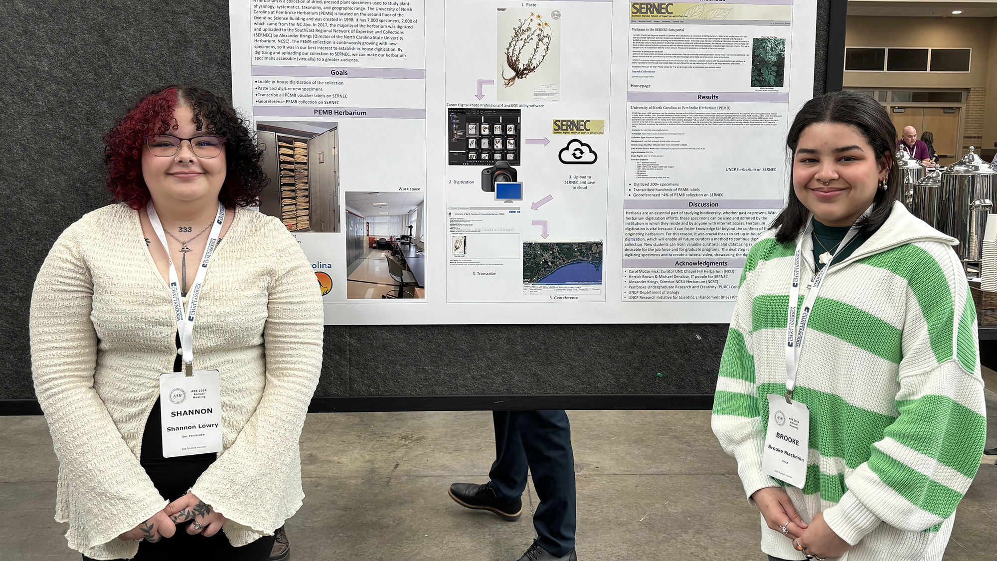 Shannon Lowry (left) and Brooke Blackmon (right) standing with a poster presentation at ASB Conference.