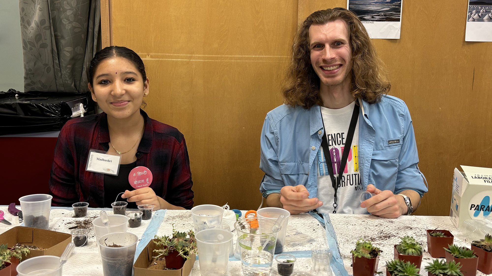 Two college students smile while working a NCAS table