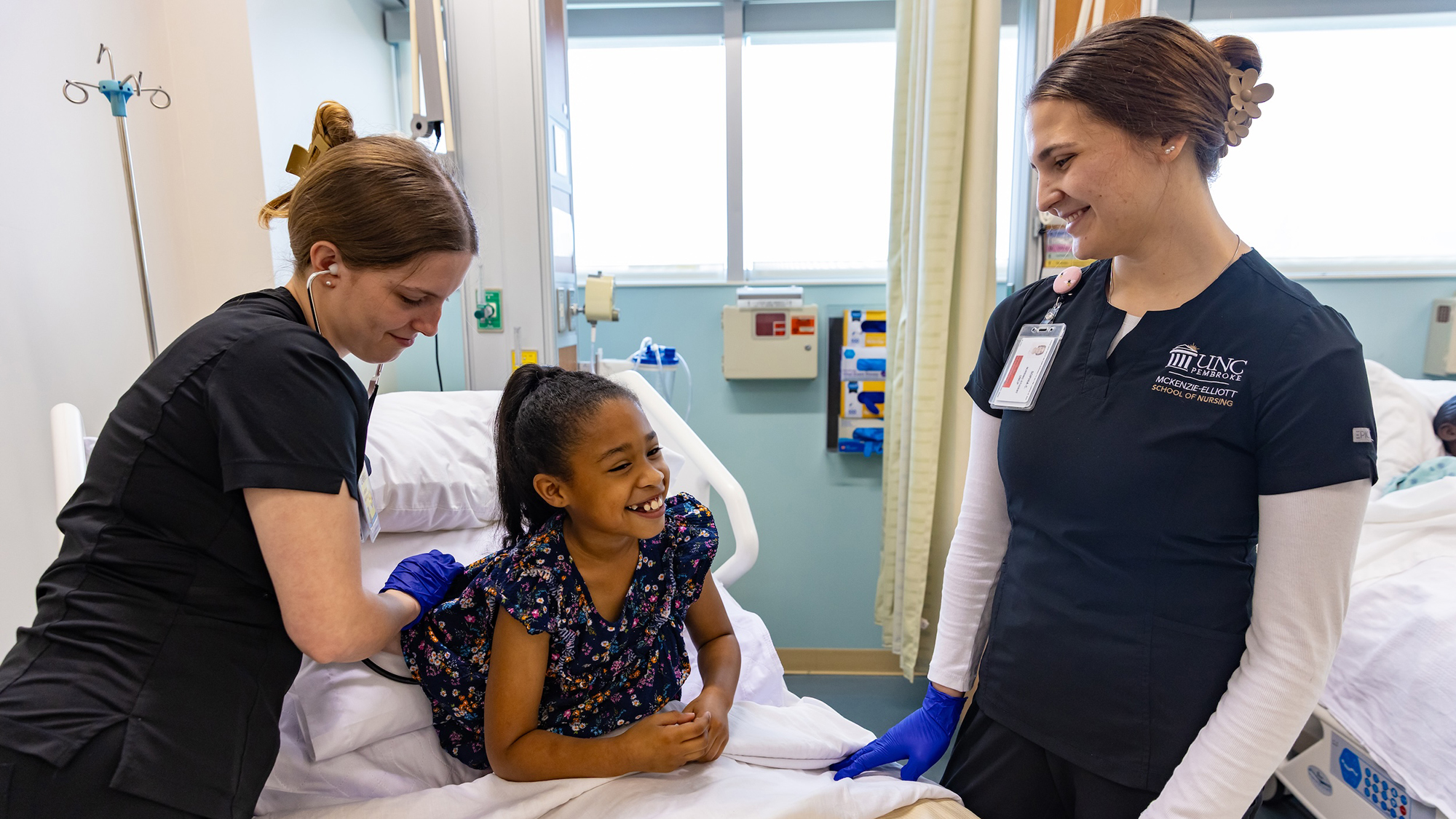 Nursing students in lab with child