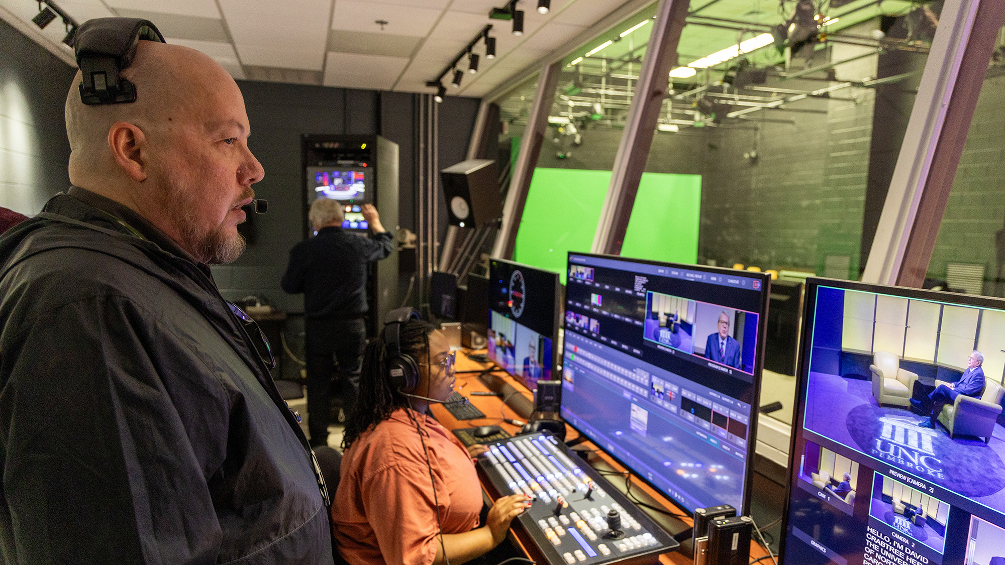 student and producer in the control room of the tv station at UNCP