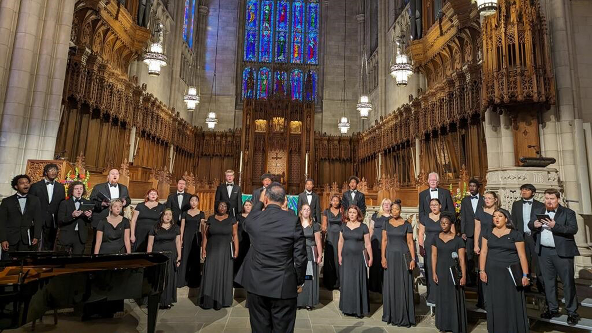 conductor conducting choir inside an ornately done chapel
