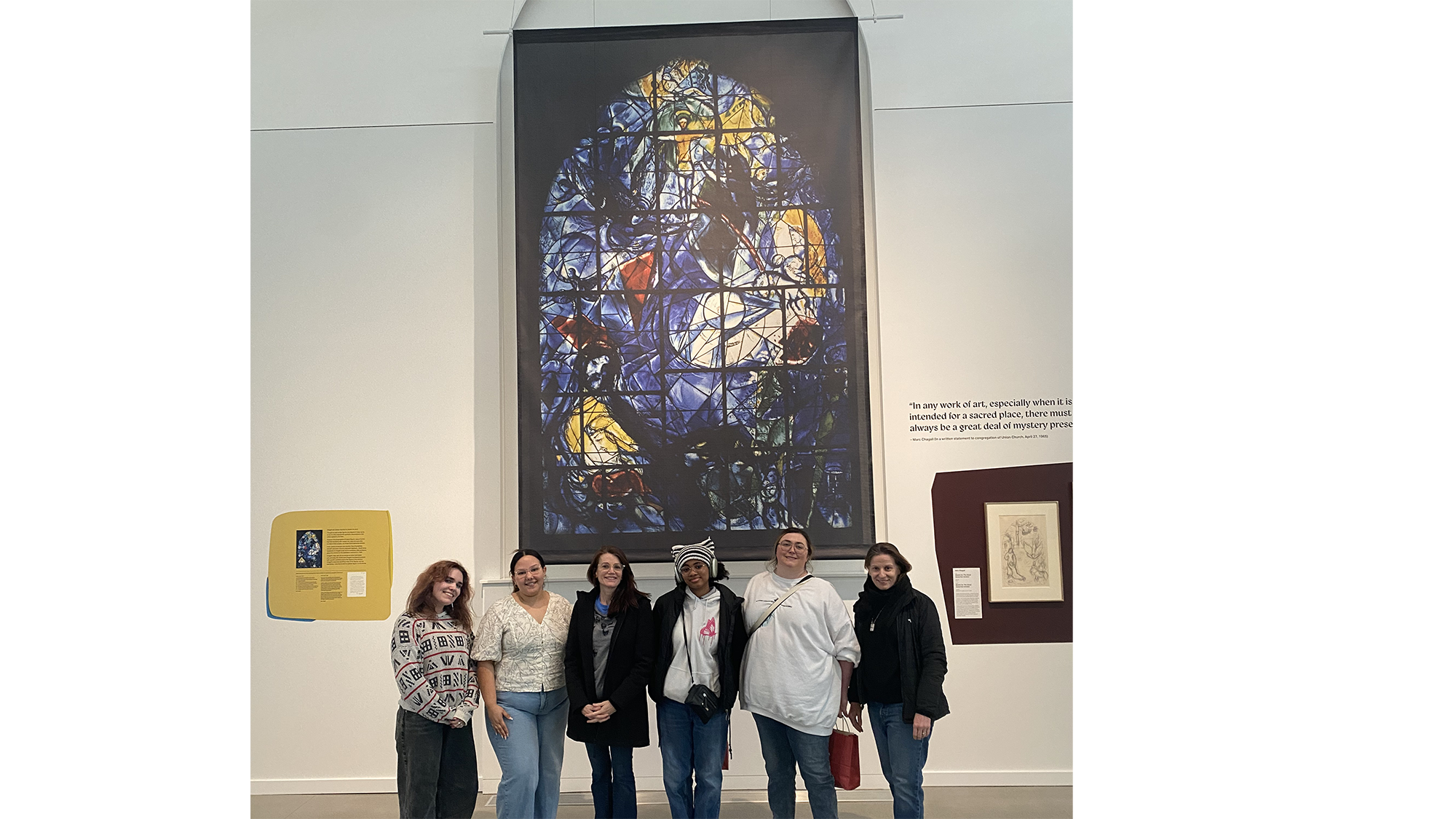 Art students and faculty standing in front of the Chagall exhibit "Sketching Light."
