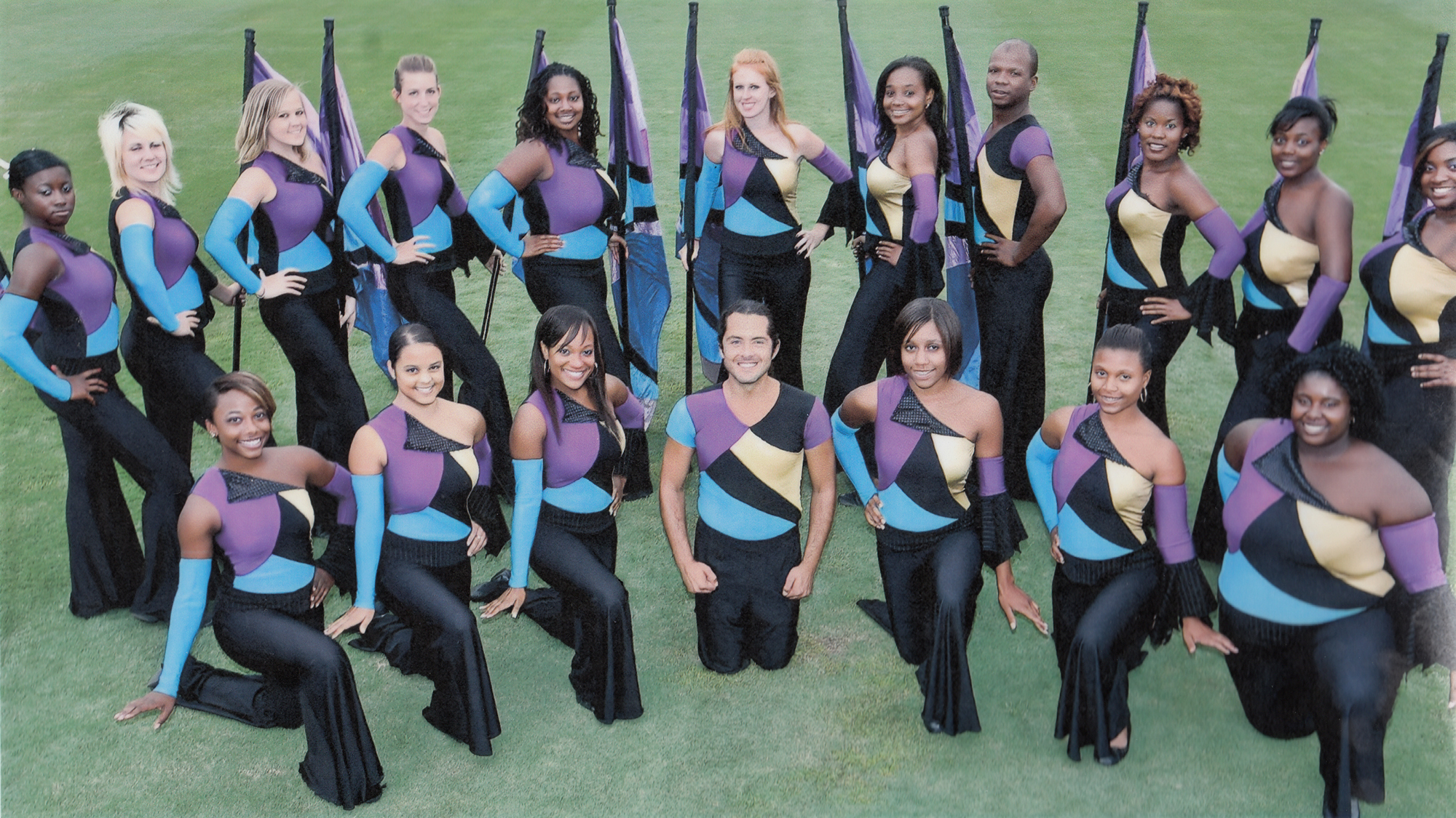 students in colorguard pose on the field for the camera