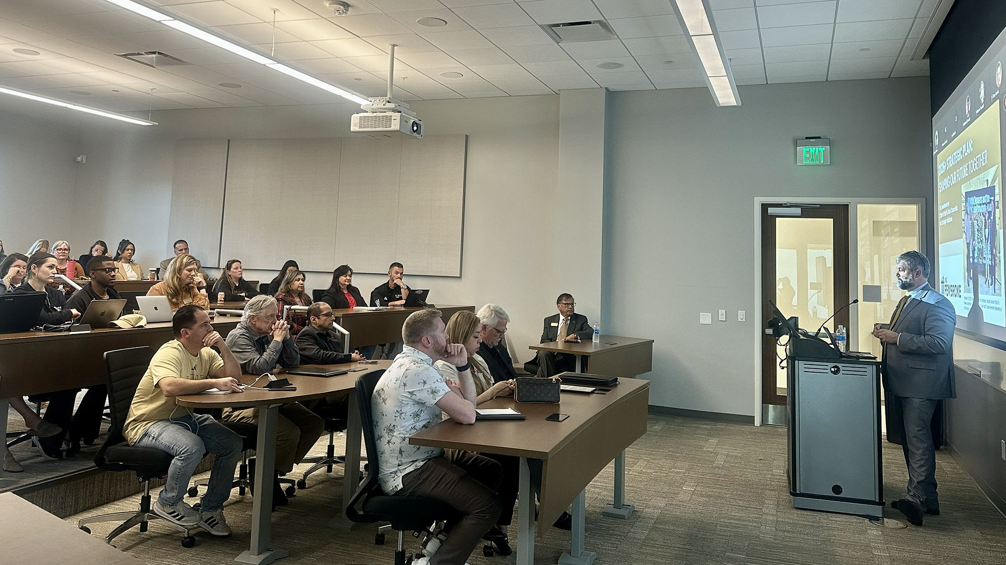 UNCP faculty and staff sit in an classroom with Chief of Staff Jess Boersma, PhD speaking from a podium