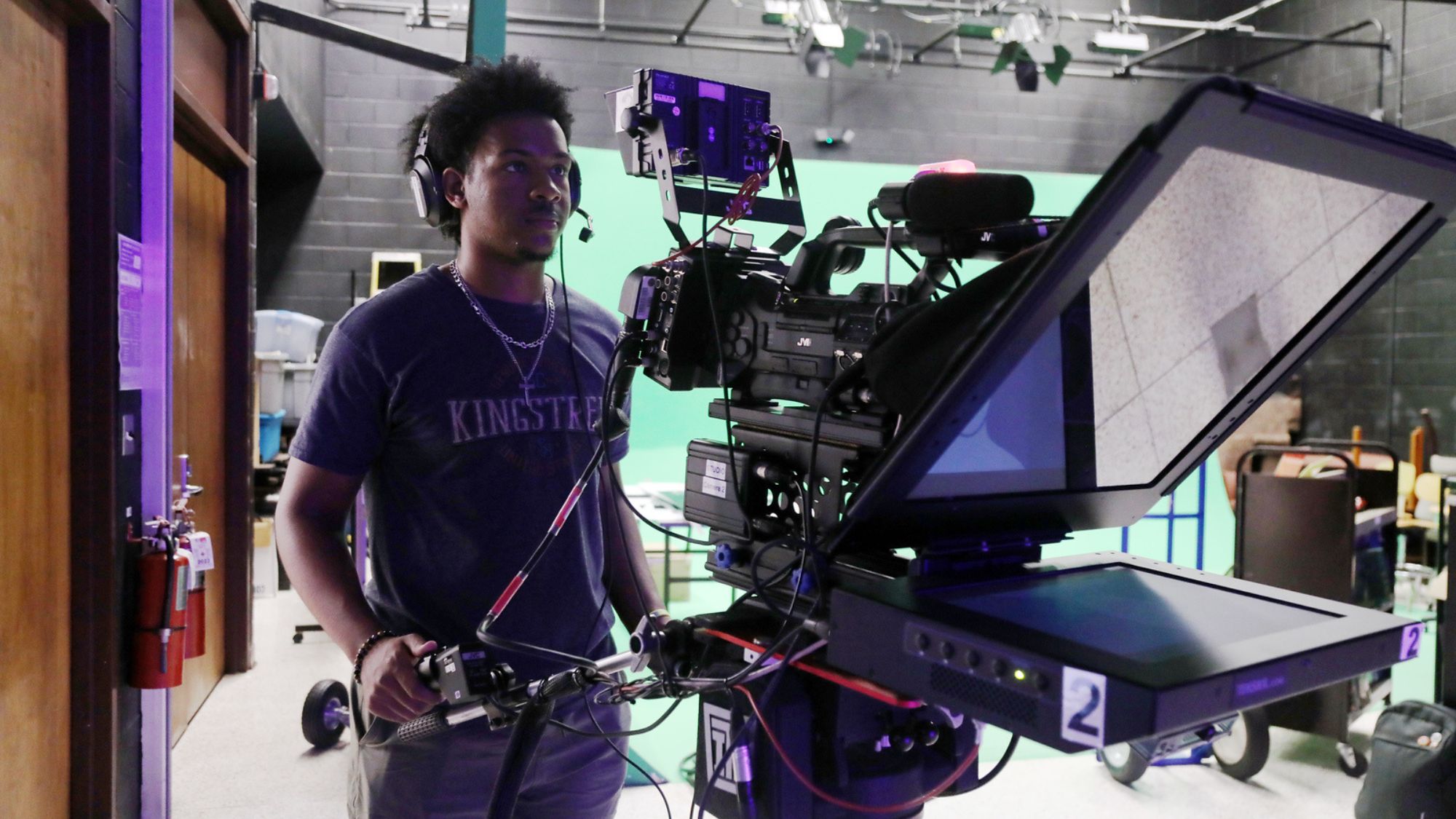 A Mass Communication student operates a camera on set during a student-produced television show.