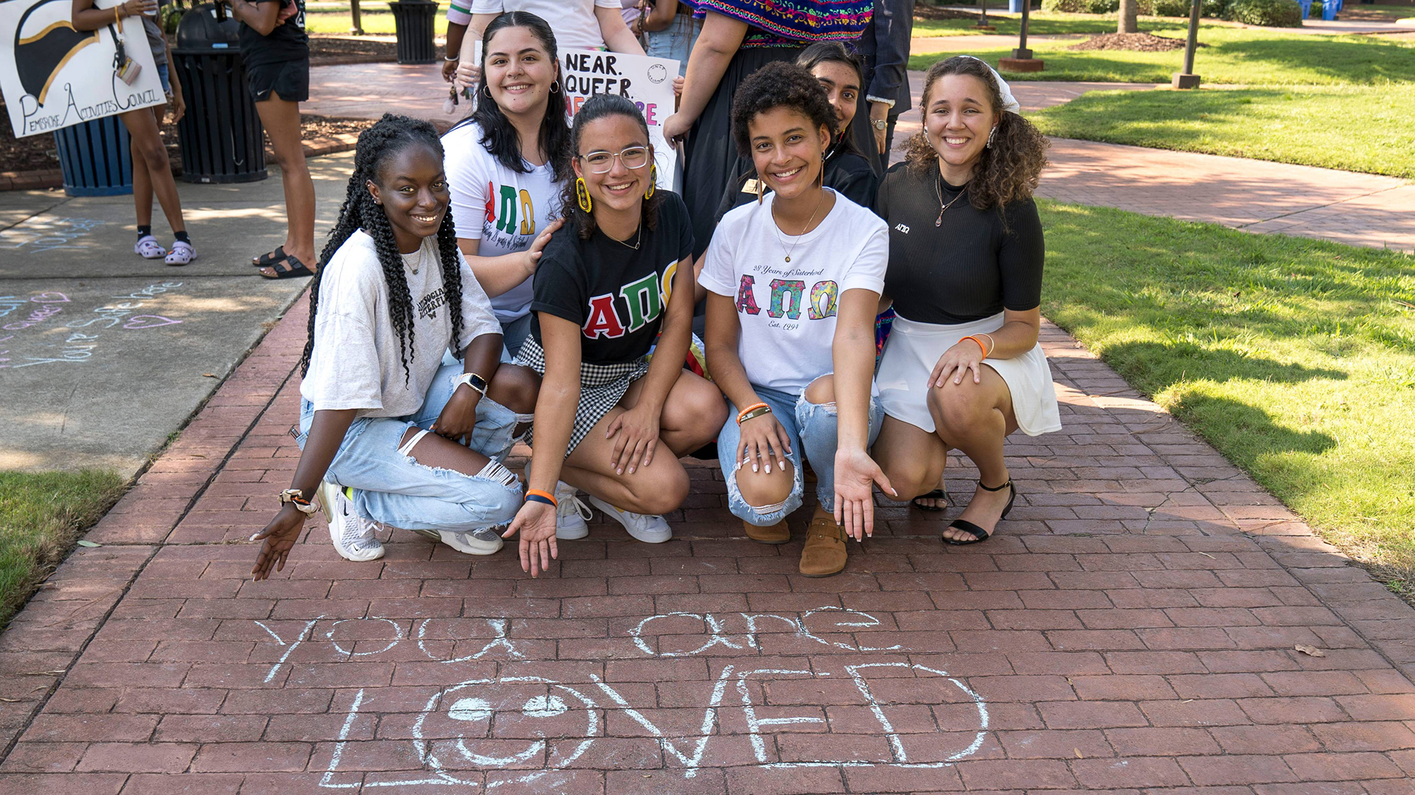 Students with chalk writing that says "You are Loved"