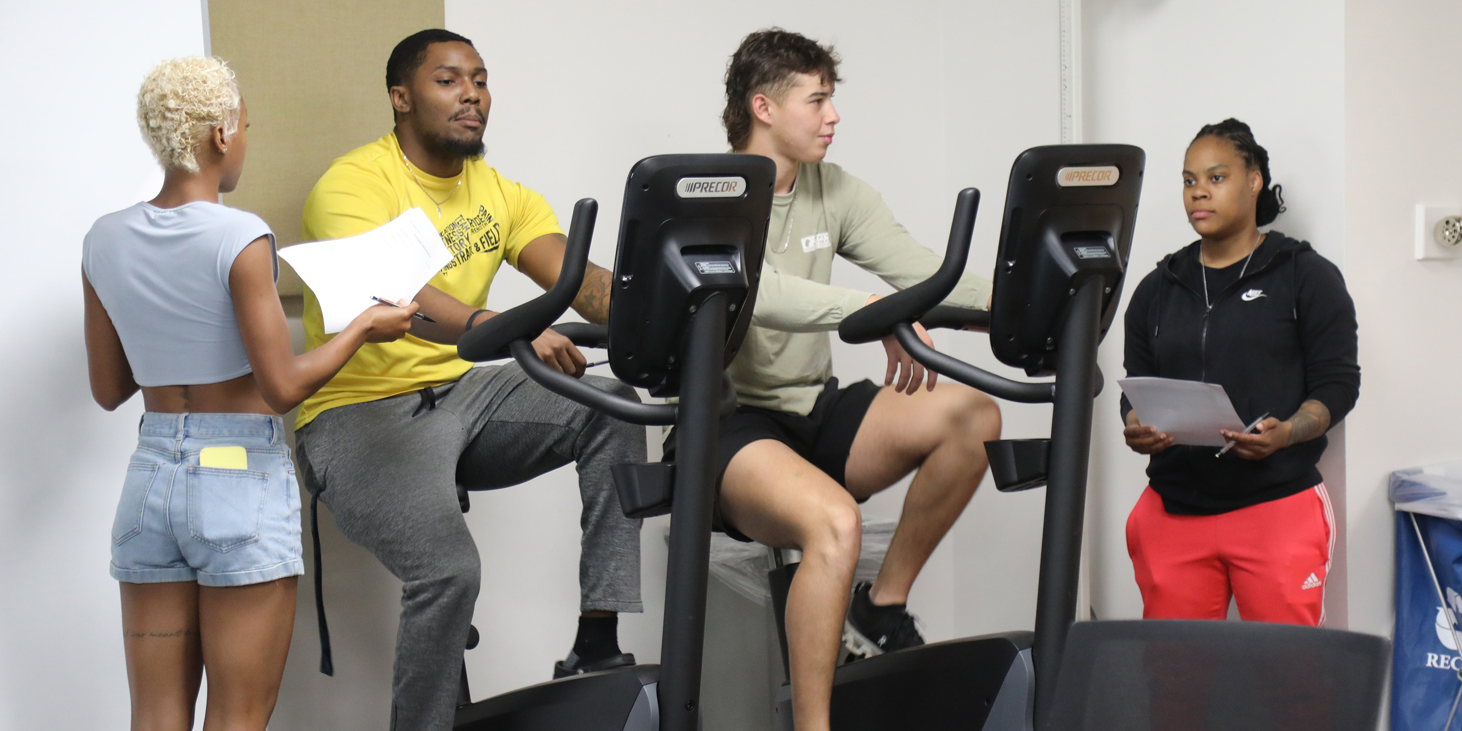 Two inesiology students evaluating two other students who are on exercise bicycles at UNC Pembroke
