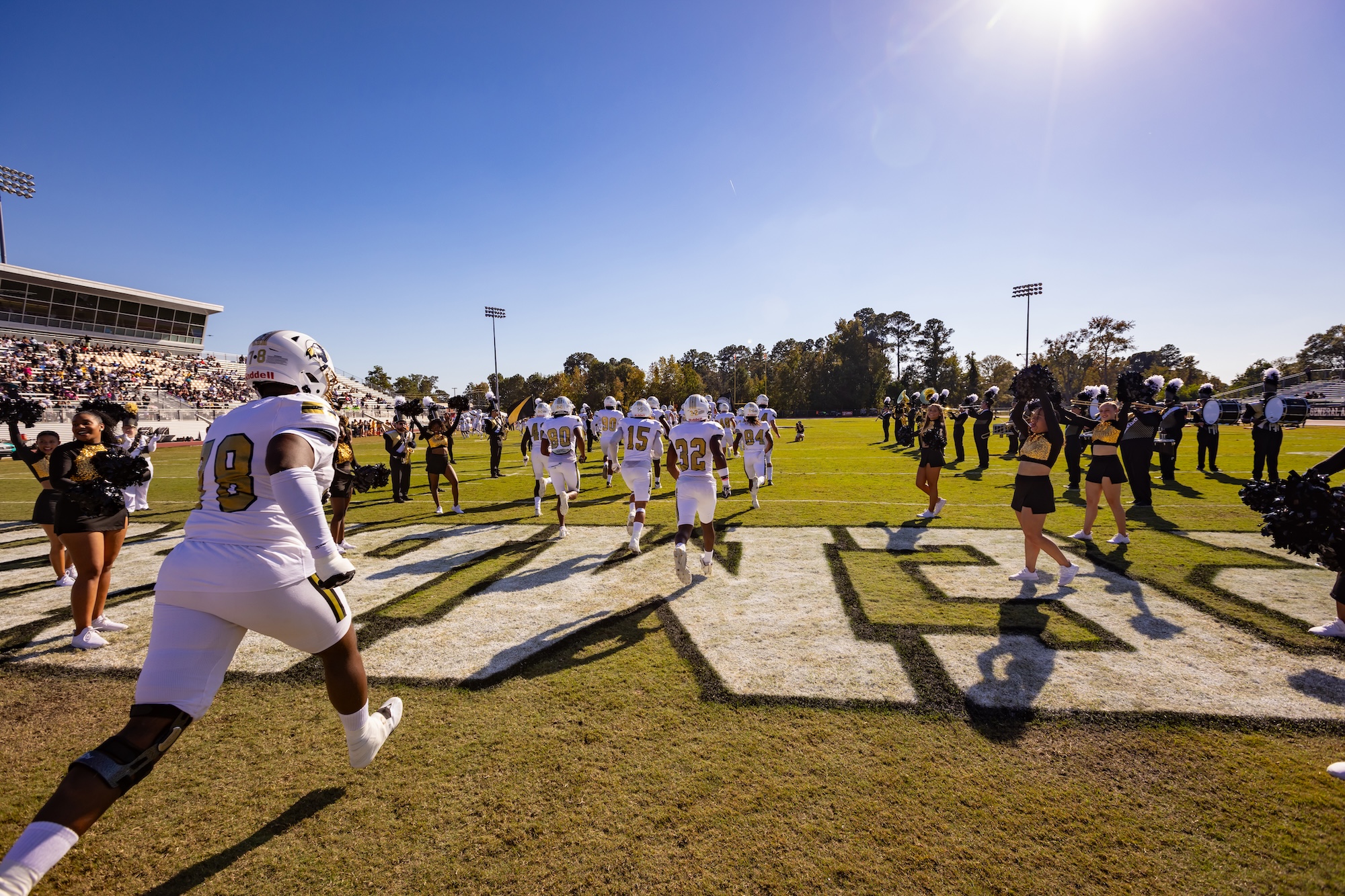Football team and cheerleaders on UNC Pembroke field on gameday