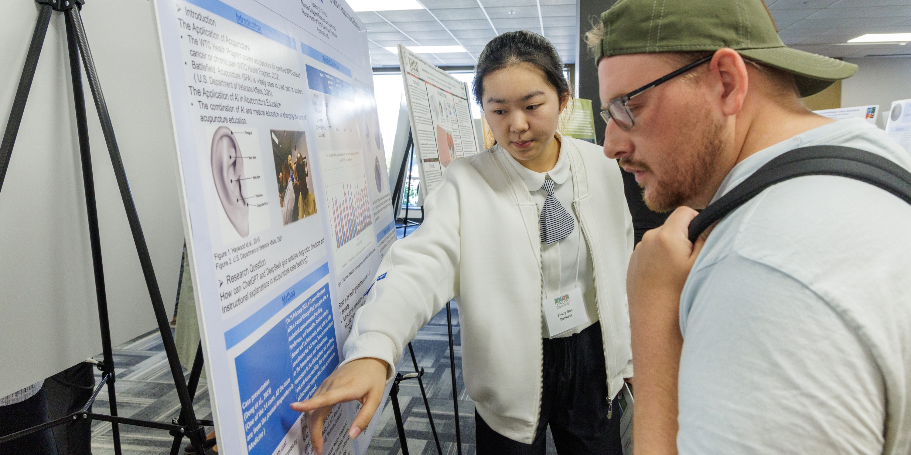 Chinese international student presenting her research during a poster session at the Pembroke Undergraduate Research and Creativity Symposium (PURC) at UNC Pembroke.