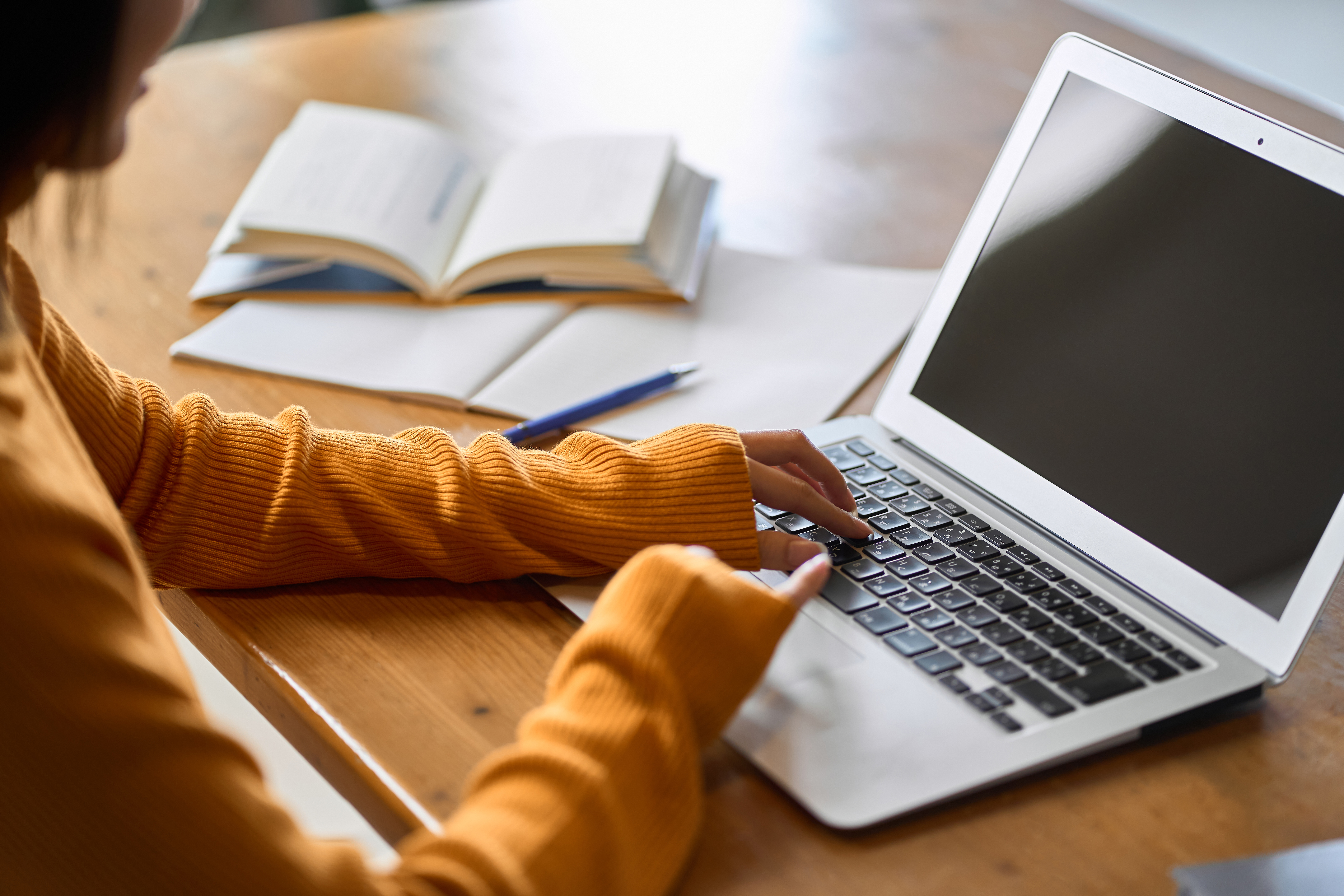Student applying for accessibility services on laptop at a table.