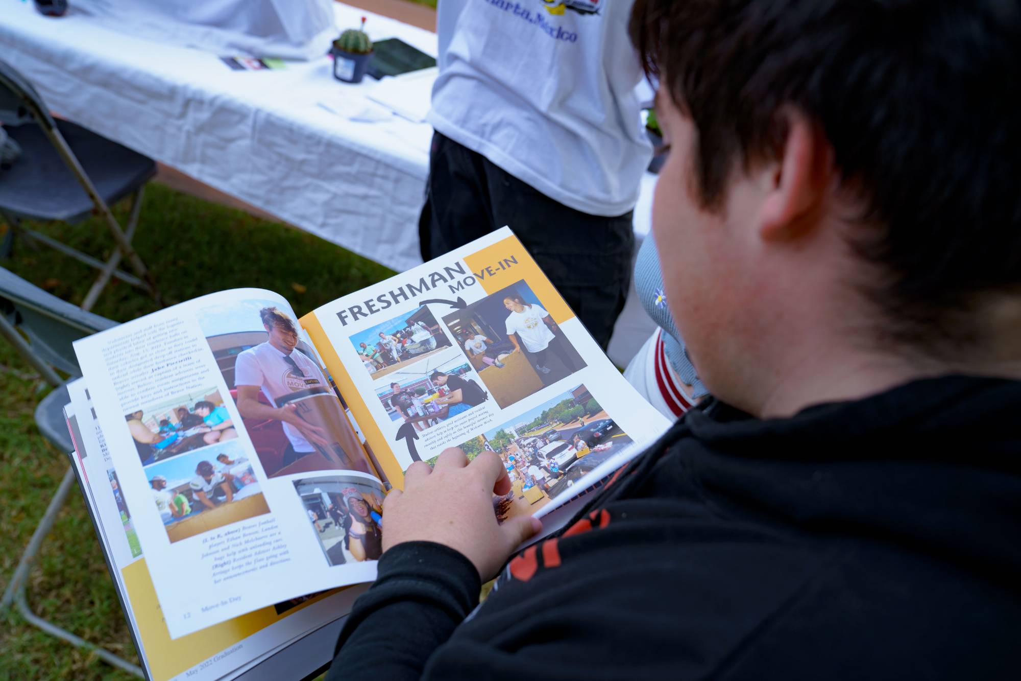 A UNCP student flipping throught the pages of the yearbook