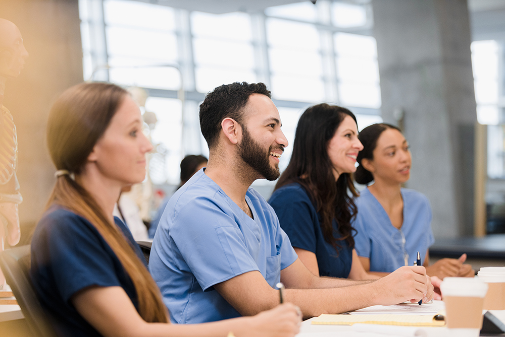 nursing students looking in a classroom smiling