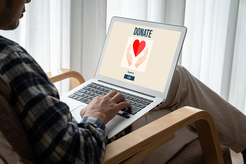 man at computer with screen that says donate