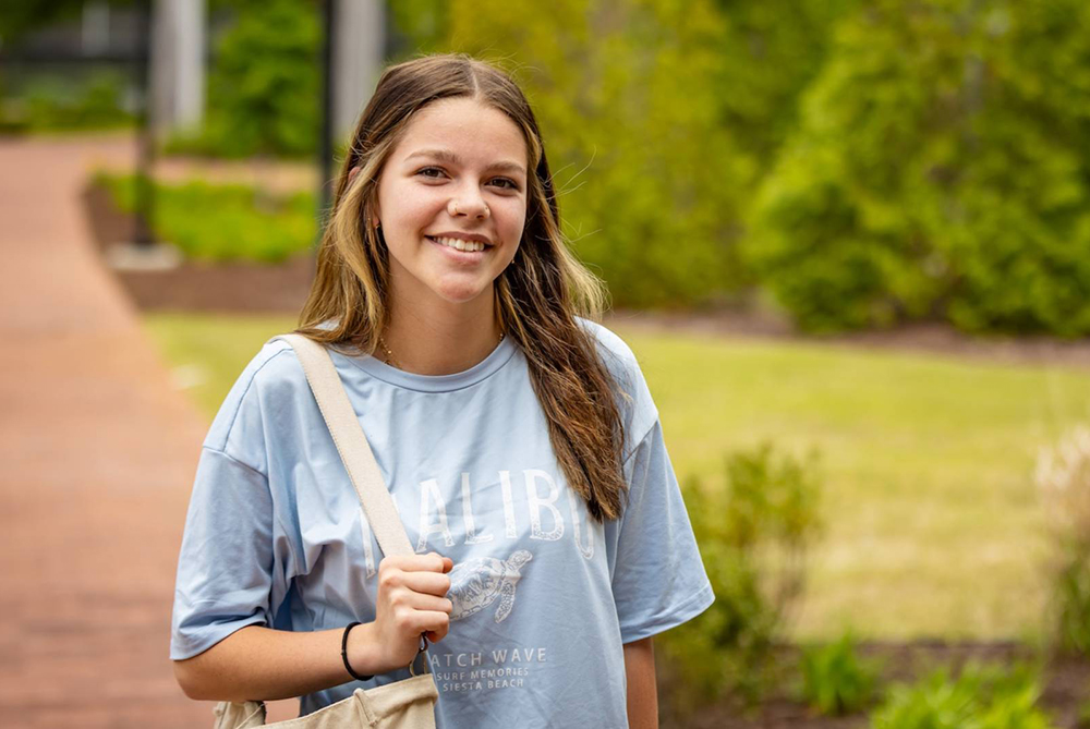 Female student posing for a picture outside