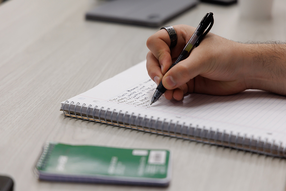 UNCP student writing notes in a notebook