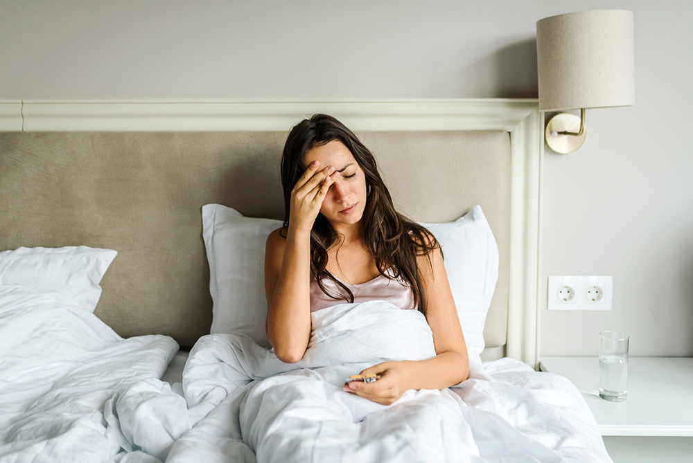 woman having trouble sleeping with head hurting