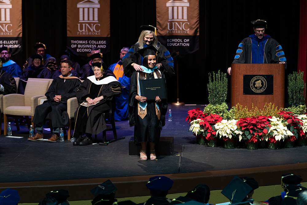 UNCP student being hooded at the graduate school commencement ceremony