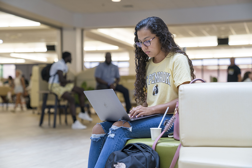 young lady on laptop UNC Pembroke