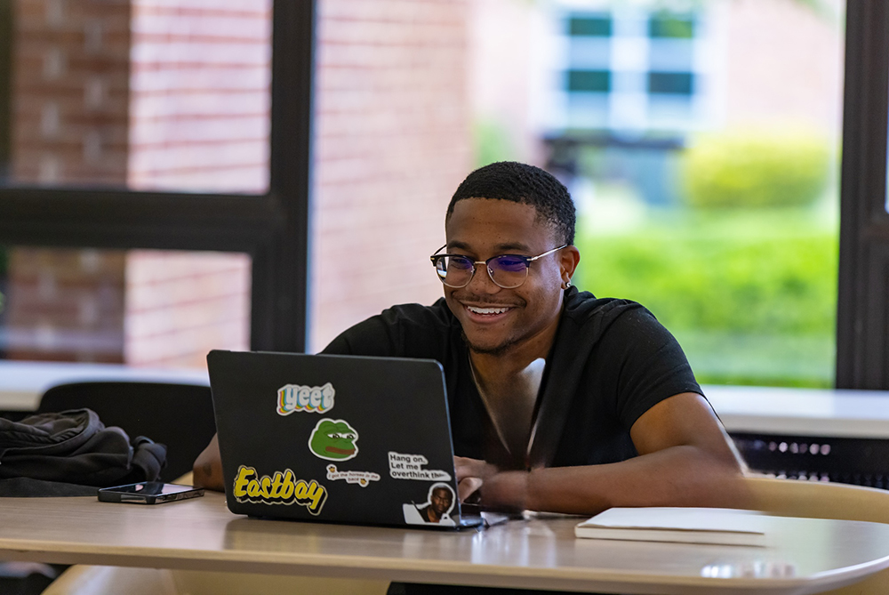 male uncp student looking at his computer