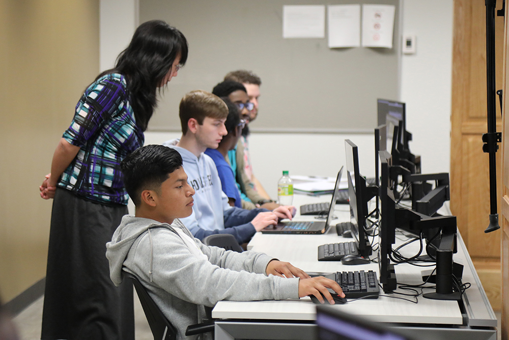 Female faculty member at UNC Pembroke in a computer lab placing viles in a centrifuge.