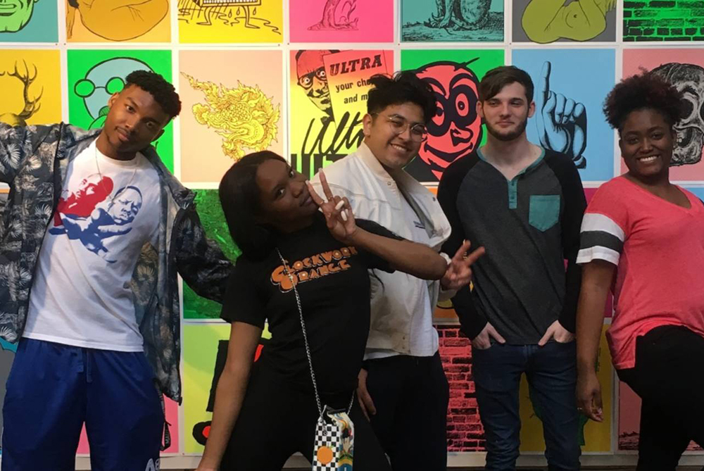 UNCP Art club members in front of a wall