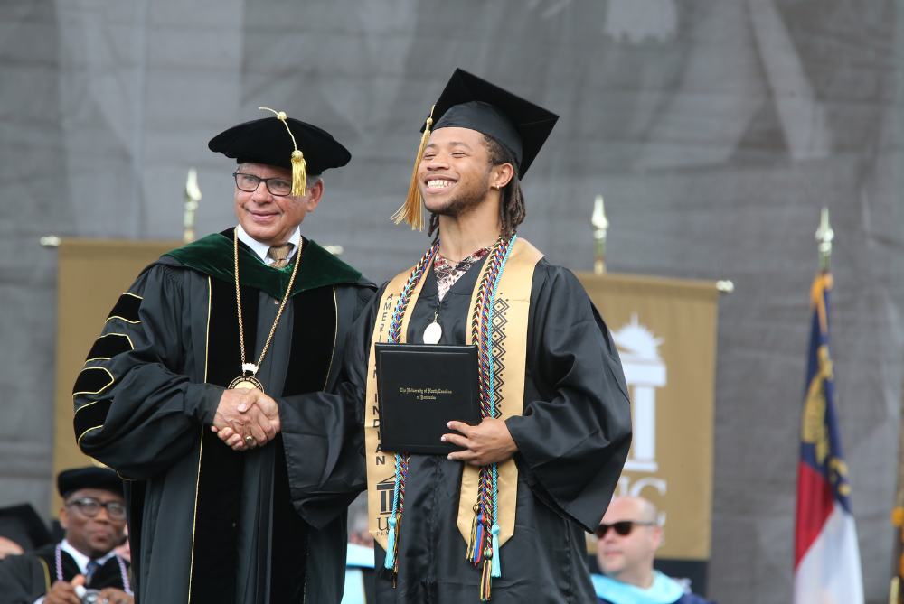 male student shaking the hand of UNC Pembroke Chancellor at commencement