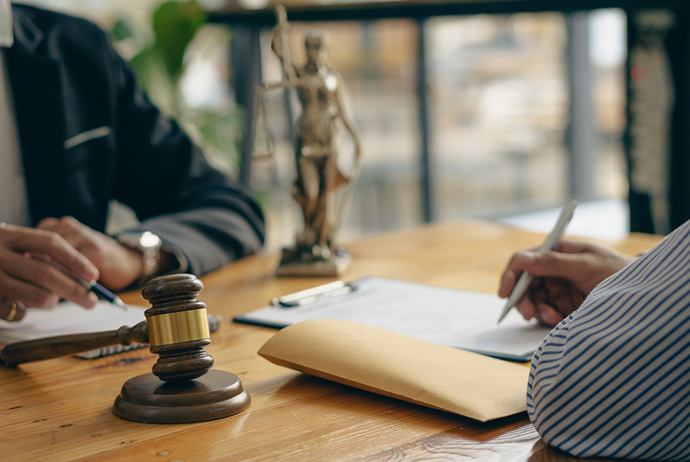 two people at a desk with scales of justice