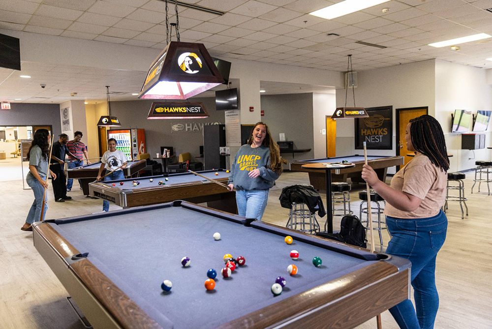 Students playing billiards in the HawksNest