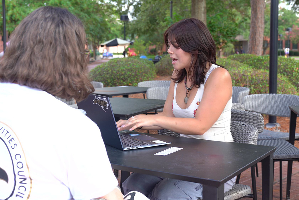 Student tutoring at an outdoor table at UNC Pembroke.