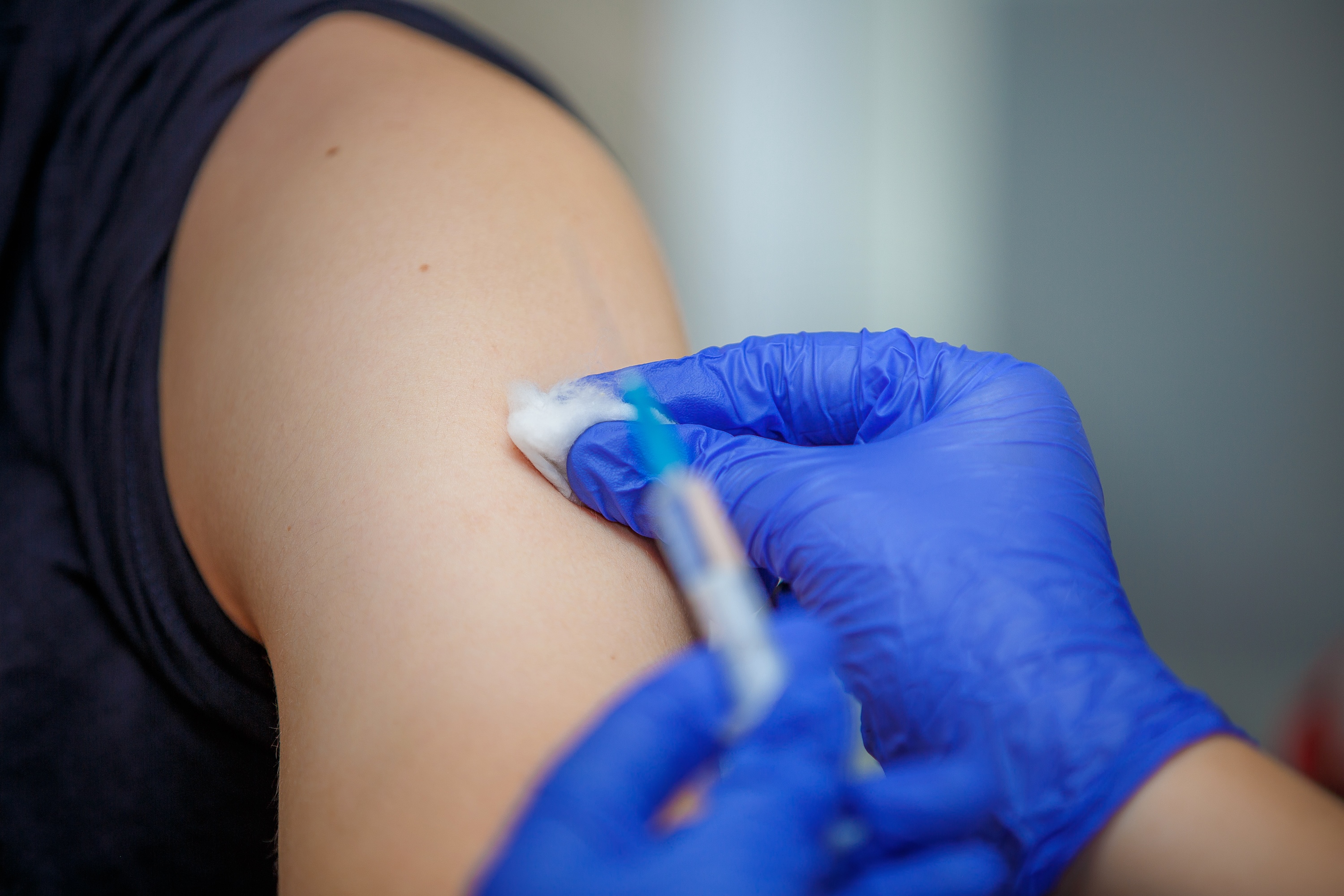 person giving shot on arm