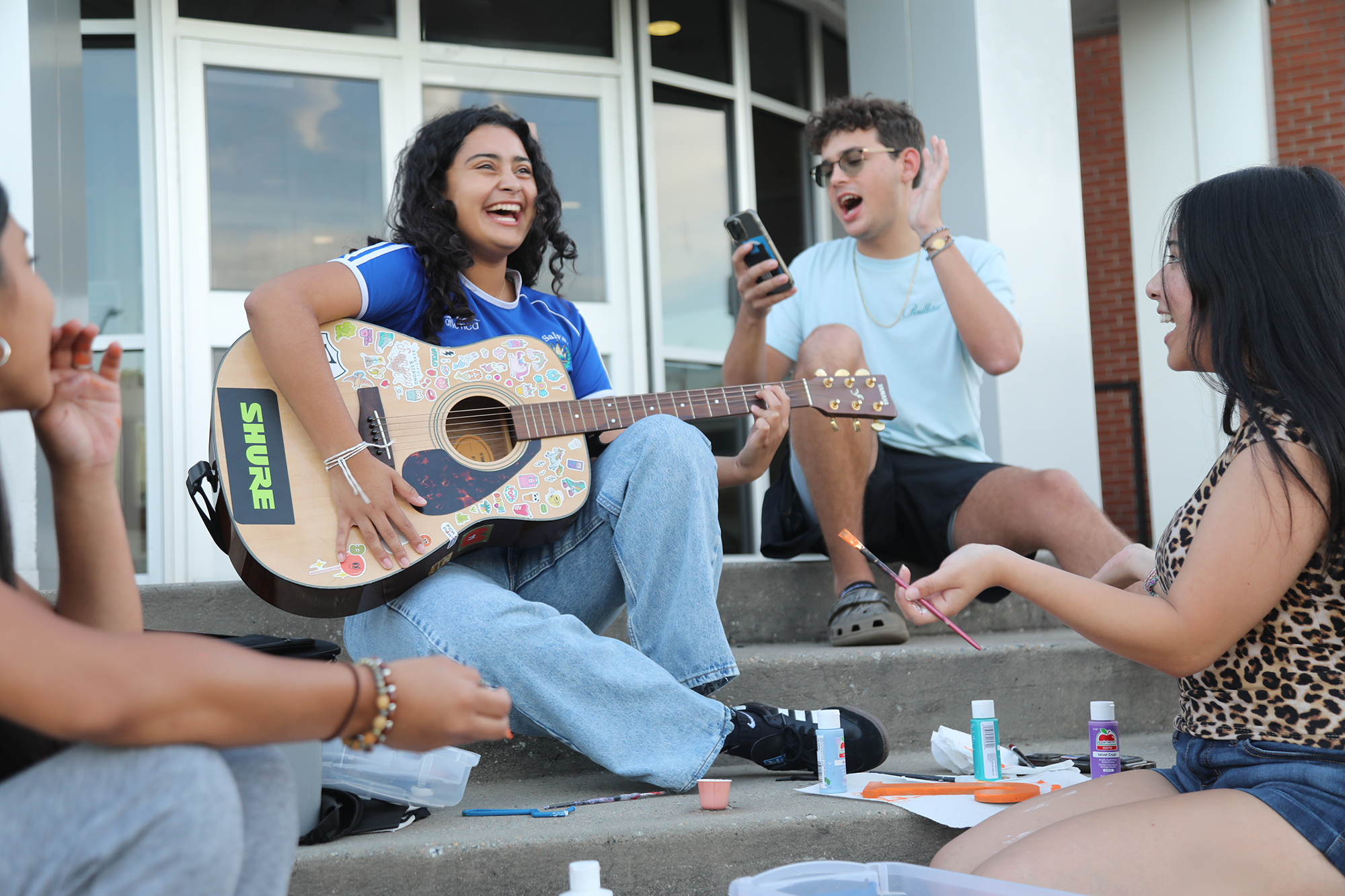 UNCP students sitting on the stairs playing music