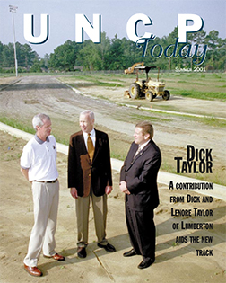 dick taylor and others at a construction site from the cover of the UNCP Today summer 2001 edition