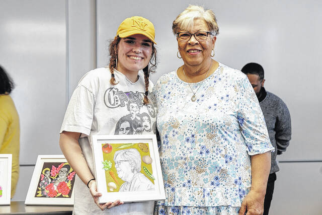 Sadie Outen with a portrait she painted of a Lumbee Tribe member as part of a project