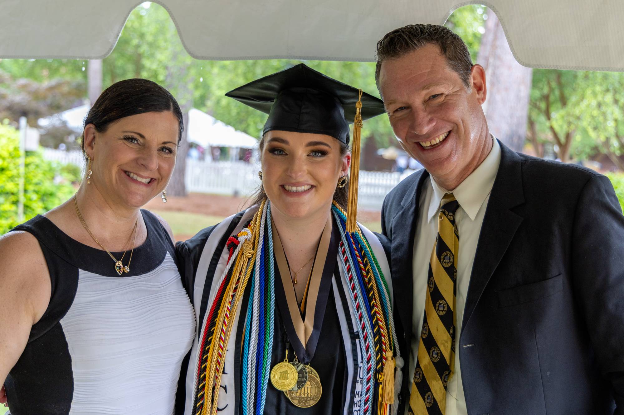 Alumna Aspen Andersson (center) with her parents at commencement