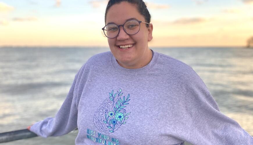 UNCP student, Kayla Benson standing against a rail with a body of water behind her