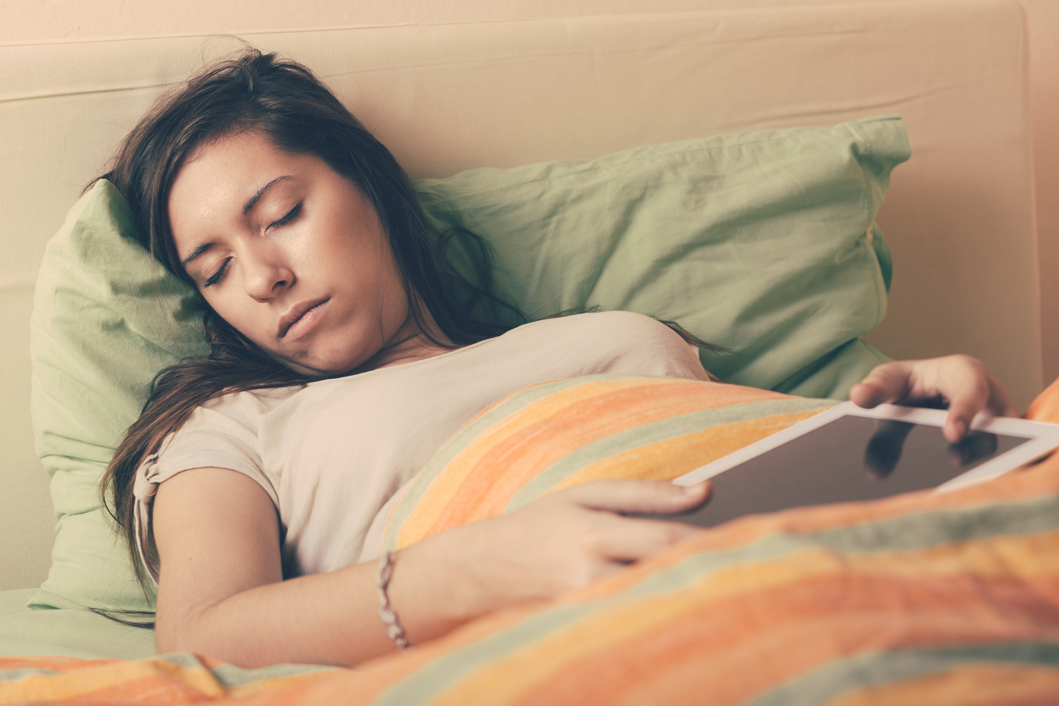 young woman asleep with tablet