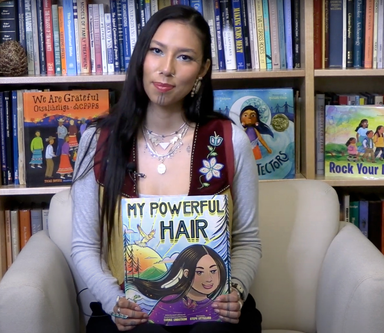 Quanah Chasinghorse holds a children's book titled "My Powerful Hair."