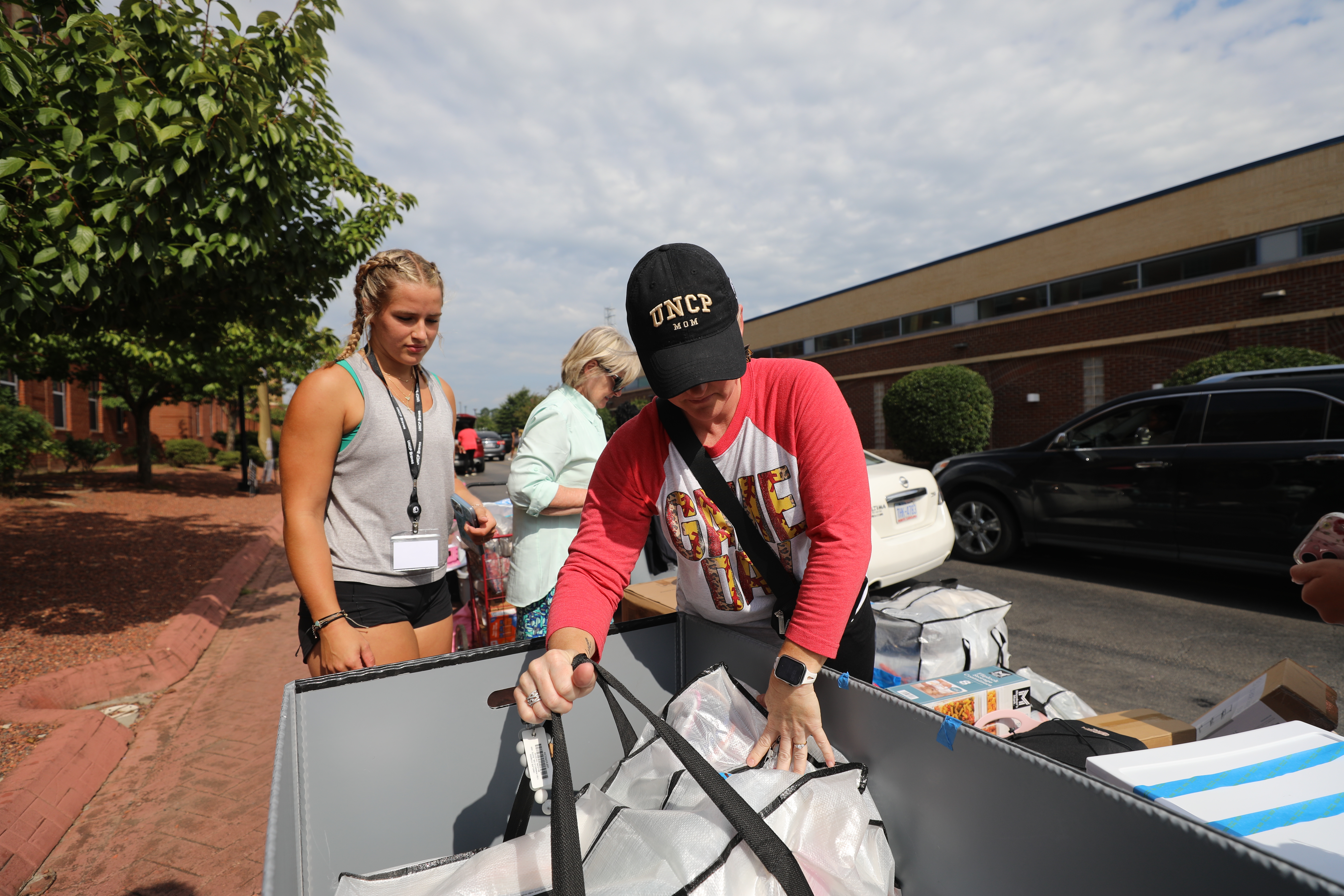 A UNCP mom helping move bags and boxes on Move-In Day