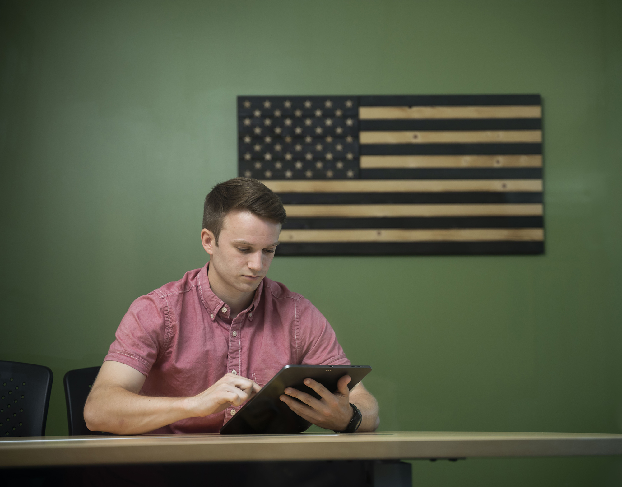 UNCP student reading in front of US flag